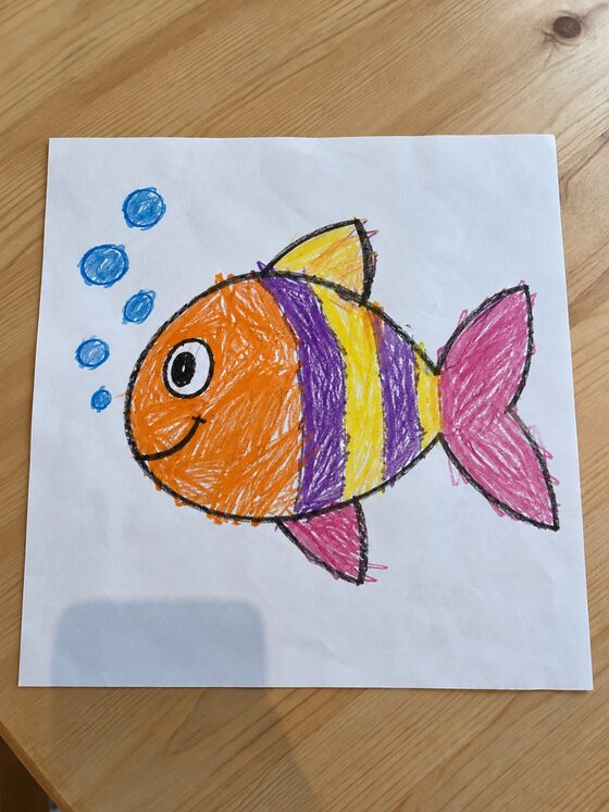 紙にクレヨンで描いた、しましまのおさかなの絵